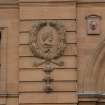 Detail of carved head within wreath on north facade