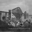 General view from the North West with houses on the Fife shore in the foreground.
Insc. 'The Forth Bridge. Length including Viaduct 8098 Ft. Height 369 Ft. Spans 1710 Ft each.  231.'