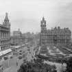 General view of Princes Street looking east towards Calton Hill showing Waverley Gardens, the North British Hotel and a busy street full of shoppers, trams, cars and horse drawn carriages.