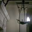 View of hanging lamp, one of a pair hanging from brackets either side of the foot of the stairs.