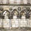 View of four carved heads in roundels, between ground floor arches on W tower of Holyrood Abbey.