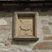 Detail of carved armorial panel on S wall.