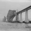 View of the Forth Bridge under construction seen from the South West shore.

