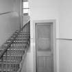 Interior.  1st floor. Etched glass door panel under secondary staircase.