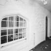 Interior. Ground floor entrance hall showing S wall of tower with arched openings