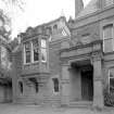 Detail of W entrance front showing porch, billiard room oriel and 1890 date stone