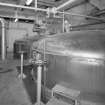 Mash House. Interior view showing its two mash tuns - the foreground unit being stainless steel, and the unit to the rear cast-iron, with a coppper top