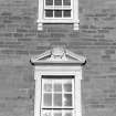 Detail of first floor window pediment on S frontage.