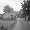 Lodge adjacent to railings and gate piers, view from driveway to S