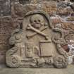 View of tomb fragment with winged hourglass, scroll, skull and skeleton, Elgin Cathedral.
