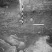 Excavation photograph : area A - offset plinth footing for east wall of chamber sealing stepped, worn rock.