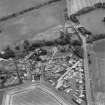 Oblique aerial view of the village of Kilrenny centred on the church, taken from the SW.
