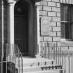View of the front door of 6 Buccleuch Place, Edinburgh with two Doric columns supporting an open pediment 
seen from the north.
