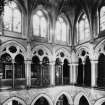 Photograph showing interior-general view of top galleries showing statuary and stained glass windows at top level