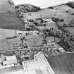 Oblique aerial view centred on the church, burial ground, walled garden and farmhouse, taken from the NNW.