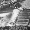 Oblique aerial view centred on the farmhouse, farmsteading and stables, taken from the SE