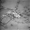 Oblique aerial view centred on the tower-house, stables and outbuildings, taken from the ESE.
