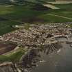 Oblique aerial view of St Monance centred on the village, church and harbour, taken from the SSW.