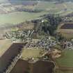Oblique aerial view centred on Monymusk village with the tower-house in the background, taken from the SW.