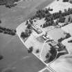 Oblique aerial view from North West of Gordon Castle estate (after demolitions), including house, tower, home farm, laundry cottages and cropmarks