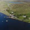 Oblique aerial view looking across Olna Firth to the village of Voe, the fish processing plant and the pier, taken from the WNW.
