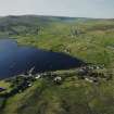 General oblique aerial view looking across Olna Firth to the village of Voe, the fish processing plant and the pier, taken from the SSE.