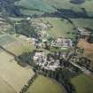 Oblique aerial view centred on the school and agricultural college with the tower-house adjacent, taken from the NW.