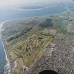 Oblique aerial view of Carnoustie golf course with the ranges and training area in the background, taken from the NE.