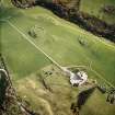 Oblique aerial view centred on the remains of the broch, building and homestead, taken from the NNE.