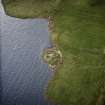 Oblique aerial view centred on the remains of the broch, taken from the NW.
