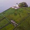 Oblique aerial view centred on the lighthouse with the remains of the dun adjacent, taken from the NE.