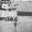 Oblique aerial view centred on the cropmarks of the ring-ditch with country house adjacent, taken from the SE.