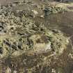 Oblique aerial view centred on the remains of the fort and possible cairn, taken from the WSW.