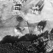 Oblique aerial view centred on the ruins of the tower-house with farmsteading adjacent, taken from the SSW.