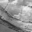 Oblique aerial view centred on the standing stone and the cropmarks of the ring-ditch and souterrain, taken from the NW.
