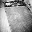 Oblique aerial view centred on the cropmarks of the enclosures with the country house adjacent, taken from the NE.