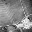 Oblique aerial view centred on the cropmarks of the plantation bank with stables adjacent, taken from the NW.