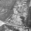 Howe Mire, oblique aerial view, taken from the SSW, centred on the cropmarks of a series of coal pits. Cropmarks of a settlement are visible in the top right-hand corner of the photograph.