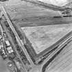 Oblique aerial view of Meadowmill centred on the cropmarks of an enclosure, taken from the E.