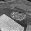 Oblique aerial view centred on the remains of the fort and settlement with cropmarks of the pit-alignments adjacent, taken from the SW.