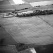 Kaeheughs, Barney Mains, oblique aerial view, taken from the SSE, centred on the remains of a fort and on the cropmarks of an enclosure and pit-alignments.