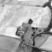 Oblique aerial view centred on the burial-ground, watermill, farmhouse, farmsteading and school, and the cropmarks of the nunnery, taken from the SW.