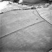 Oblique aerial view of Whitelaw Hill taken from the NNE, centred on the cropmarks of a fort. A pit-alignment is visible in the centre left half of the photograph.