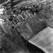 Oblique aerial view. General view of the village taken from the NE with a recorded site of cropmarks   (NT77SE 27) visible to the W.