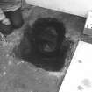 Excavation photograph.  F13 removal of fill. Pot shows much of base missing.