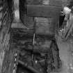 Excavation photograph : area Q - red sandstone curtain wall cut by waste pipe trenches and overlain by wall 1031.