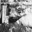 Excavation photograph: area H/X - showing surviving midden material on top of bedrock, sealed by demolition rubble from Storekeepers House.