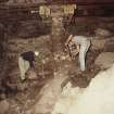 Excavation photograph : working shots in basement of cart shed beside 1066 wall and tunnel.