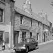 General view of 7 and 9 High Street, Pittenweem, with car parked.