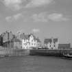 General view of 3-7 The Gyles and Gyles House, Pittenweem, with harbour and boat.